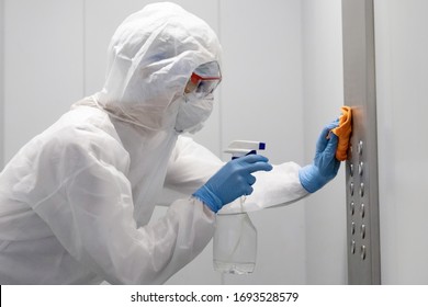 Concept coronavirus disinfection. People in hazmats making cleaning in lift apartment.