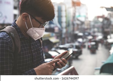 Concept of coronavirus quarantine. MERS-Cov, Novel coronavirus (2019-nCoV), man with medical face mask using the phone to search for news.Air pollution 