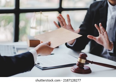 Concept of corruption, bankruptcy court, bail, crime, bribery, fraud, Judge Gavel, soundboard and a handful of cash on the table. - Shutterstock ID 2187128277