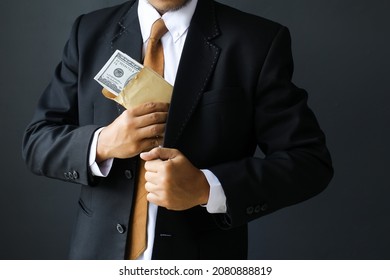 Concept for corruption, finance profit, bail, crime, bribing, fraud, auction bidding Bundle of dollar cash in hand - Shutterstock ID 2080888819