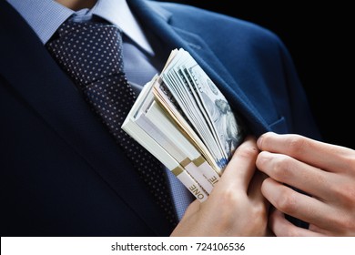Concept for corruption, finance profit, bail, crime, bribing, fraud, auction bidding Bundle of dollar cash in hand - Shutterstock ID 724106536