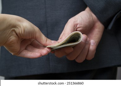 Concept - corruption. Giving a bribe. Money in hand - Shutterstock ID 251366860