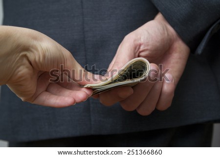 Concept - corruption. Giving a bribe. Money in hand