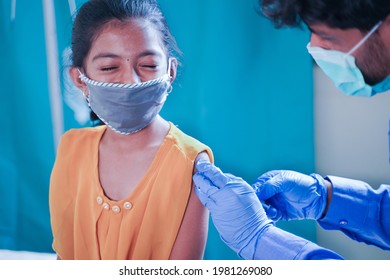 Concept of Covid-19 coronavirus vaccination for children - Young girl kid getting jab or vaccinated to against covid at hospital.
