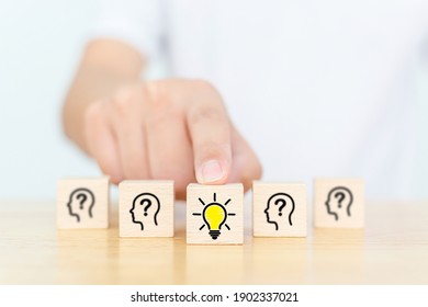 Concept creative idea and innovation. Hand choose wooden cube block with head human symbol and light bulb icon - Shutterstock ID 1902337021