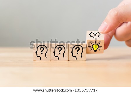 Concept creative idea and innovation. Hand flip over wooden cube block with head human symbol and light bulb icon