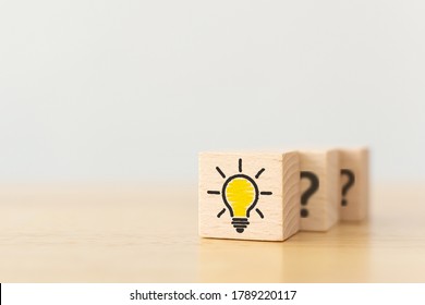 Concept creative idea and innovation. Wooden cube block with light bulb icon and question mark symbol