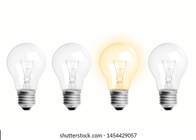 The Concept Is Creative Ideas. Image Of 4 Light Bulbs Arranged In 1 Tube With Yellow Light. All Are On A White Background.