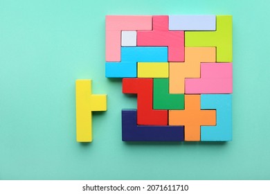 Concept of creative, logical thinking. Different colorful shapes wooden blocks on light background. Geometric shapes in different colors. Child development. Riddle and its solution. Logic tasks.