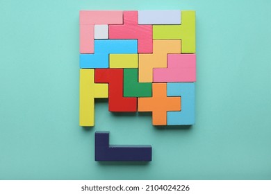 Concept of creative, logical thinking. Different colorful shapes wooden blocks on light background. Geometric shapes in different colors. Child development. Riddle and its solution. Logic tasks.