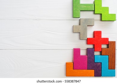  Concept of creative, logical thinking.  Different colorful shapes wooden blocks on white wooden background, flat lay, copy space. Geometric shapes in different colors, top view. Abstract Background.