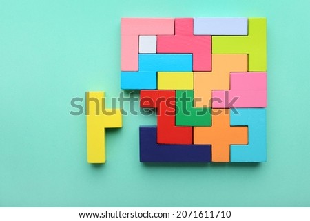 Concept of creative, logical thinking. Different colorful shapes wooden blocks on light background. Geometric shapes in different colors. Child development. Riddle and its solution. Logic tasks.