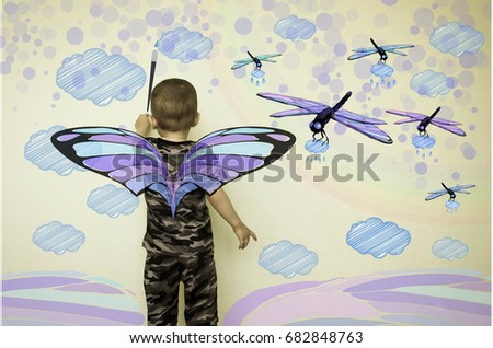 Concept of creativity child. The little boy draws on the wall. Flying dragonflies. Fantasy for children. Photo illustration for your design.