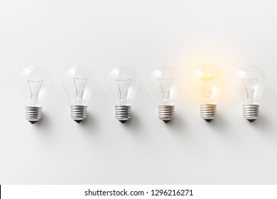 Concept For Creativity, Innovation And Solution. Illuminated Light Bulb In Row Of Dim Ones On White Background