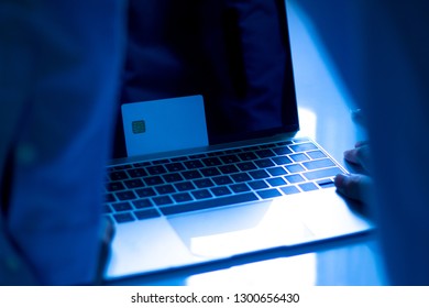 The Concept Of Credit Card Theft. Hackers With Credit Cards On Laptops Use These Data For Unauthorized Shopping. Unauthorized Payments From Credit Card Owners. In The Hacker's Secret Office