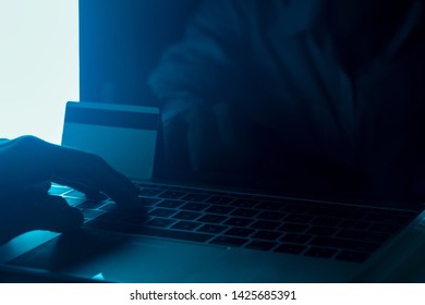 The Concept Of Credit Card Theft. Hackers With Credit Cards On Laptops Use These Data For Unauthorized Shopping. Unauthorized Payments From Credit Card Owners. In The Hacker's Secret Office