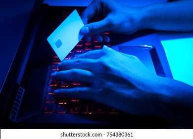 The Concept Of Credit Card Theft. Hackers With Credit Cards On Laptops Use These Data For Unauthorized Shopping. Unauthorized Payments From Credit Card Owners. Side View