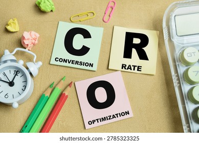 Concept of CRO - Conversion Rate Optimization write on sticky notes isolated on Wooden Table.