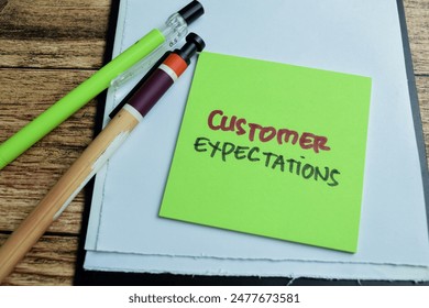 Concept of Customer Expectations write on sticky notes isolated on Wooden Table.