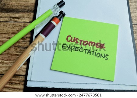 Concept of Customer Expectations write on sticky notes isolated on Wooden Table.