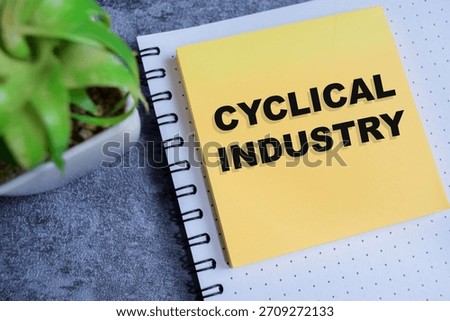 Concept of cyclical industry write on sticky notes isolated on Wooden Table.