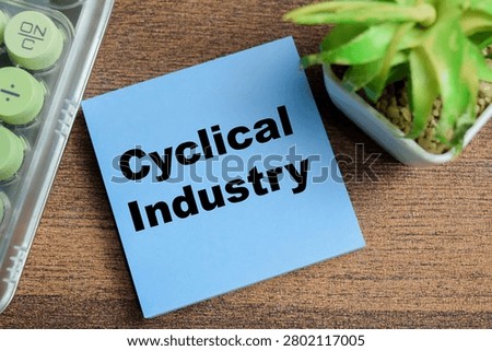 Concept of cyclical industry write on sticky notes isolated on Wooden Table.