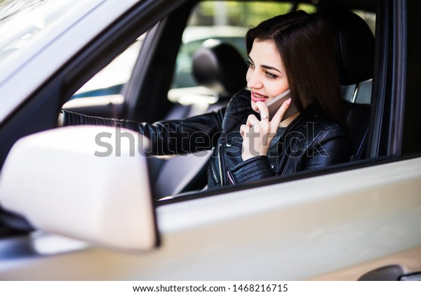 Concept danger driving Woman using cell phone while\
driving car