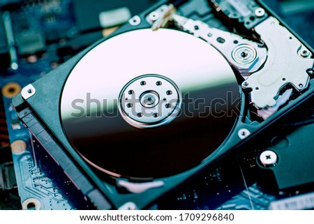 The concept of data, hardware, and information technology, the image of inside of hard disk drive on the technician's desk and a computer motherboard, toned