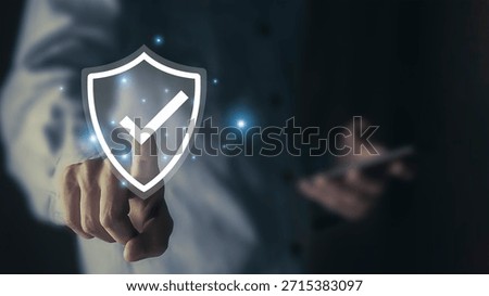 The concept of data protection and security features a businessperson holding a virtual shield with a checkmark icon, representing technology for improving the quality of business services.