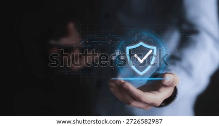 The concept of data protection and security features a businessperson holding a virtual shield with a checkmark icon