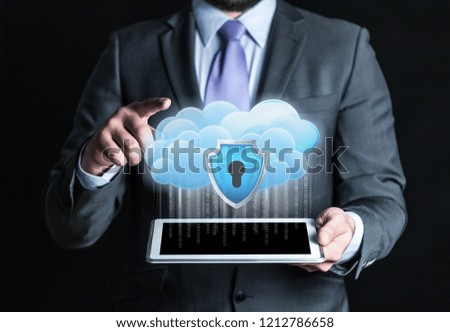 Concept Data protection in tablet . Data cloud with a protective shield shows the businessman.