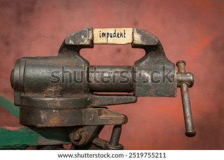 Concept of dealing with problem. Vice grip tool squeezing a plank with the word impudent