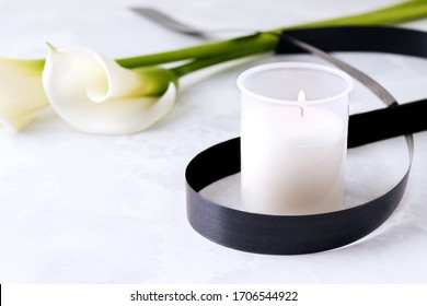 The Concept Of Death And Grief. Mourning Candle On A Concrete Background Next To White Flowers. Copy Space