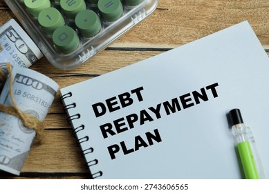 Concept of debt repayment planning write on book isolated on Wooden Table. For personal finance management and loan payoff strategy with budgeting