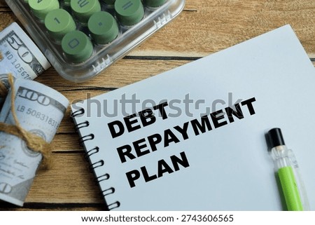 Concept of debt repayment planning write on book isolated on Wooden Table. For personal finance management and loan payoff strategy with budgeting