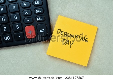 Concept of Debunking Day write on sticky notes isolated on Wooden Table.