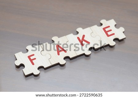 Concept of deception and falsehood illustrated with interlocking wooden puzzle pieces forming “FAKE.”