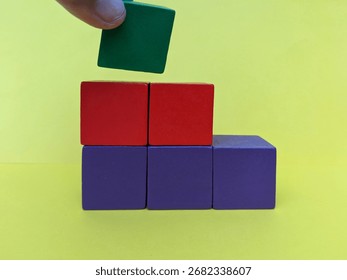 Concept of decision making process, logical thinking. Logical tasks. Conundrum, find the missing piece of the proposed. Hand holding wooden puzzle element. Hand sets the last element of the puzzle