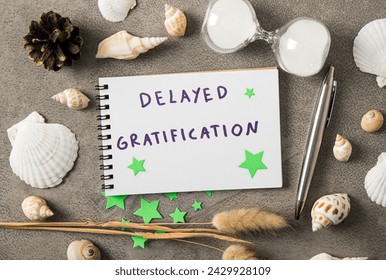 Concept of delayed gratification. Text on paper decorated with seashells indoors studio shot.