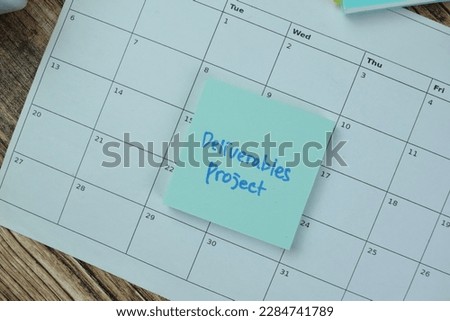 Concept of Deliverables Project write on sticky notes isolated on Wooden Table.
