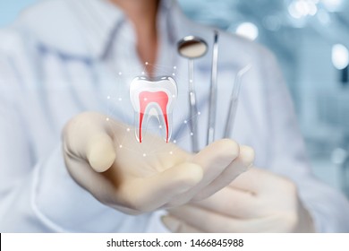 Das Konzept der zahnärztlichen Behandlung. Der Arzt zeigt einen Zahn in der Hand.