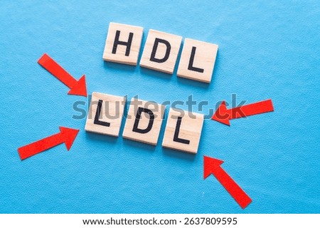 Concept of difference between HDL and LDL cholesterol, with terms composed with wooden alphabet on a blue background; bad cholesterol LDL.
