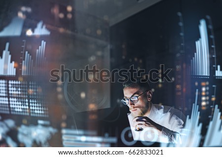 Concept of digital diagram,graph interfaces,virtual screen,connections icon.Young finance analist working at modern office.Man using contemporary laptop at night,blurred background.Horizontal
