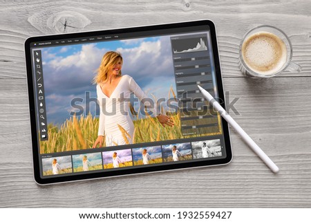 Concept of digital photo editing on tablet computer with wireless stylus pen