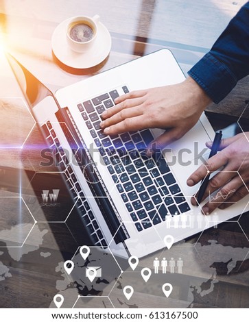 Concept of digital screen,virtual connection icon,diagram,graph interfaces.Man working with laptop at office at wooden table.Reflections on glass surface.Flares effect.Vertical