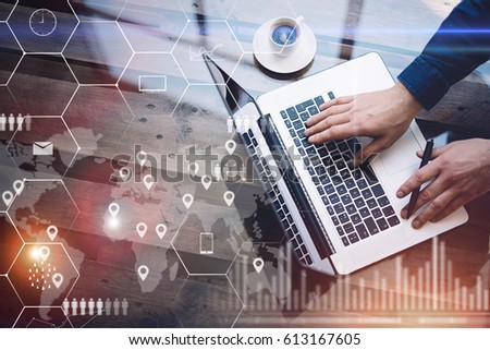 Concept of digital screen,virtual connection icon,diagram,graph interfaces.Man working with laptop at office at wooden table.Reflections on glass surface.Flares effect.Horizontal