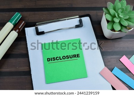 Concept of Disclosure write on sticky notes isolated on Wooden Table.