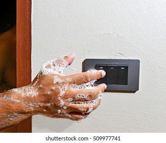 The Concept Of Do Not Turn The Power Off While Wet Hands May Cause Electric Shock And Death. Male Wet Hands Dirty Bubbles To Press The Power Switch Lights.