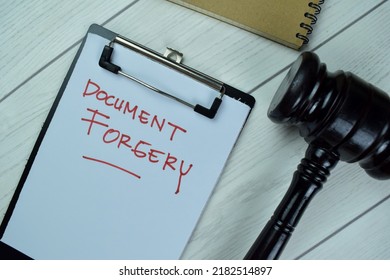 Concept Of Document Forgery Write On A Paperwork With Gavel Isolated On Wooden Table.