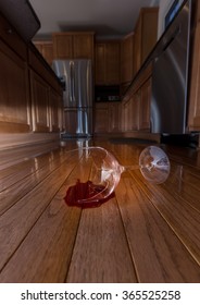 Concept Of Domestic Disturbance At Home With Broken Wine Glass On Floor Of Modern Kitchen